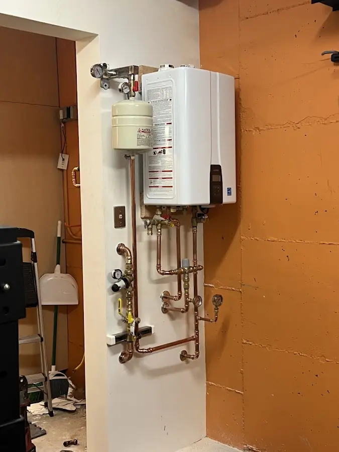 Plumbing technician inspecting water heater connections in West Hazleton